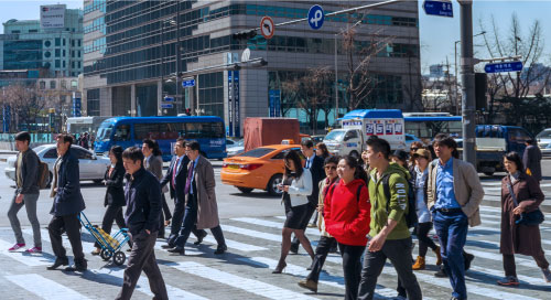 人們穿過繁忙的城市人行橫道。